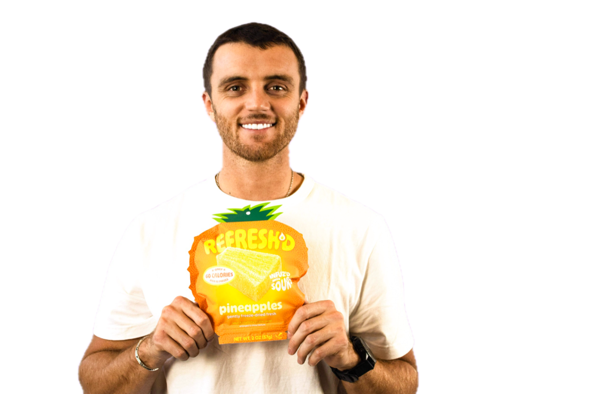 Someone holding a pouch of REFRESH'D sour freeze-dried pineapples.