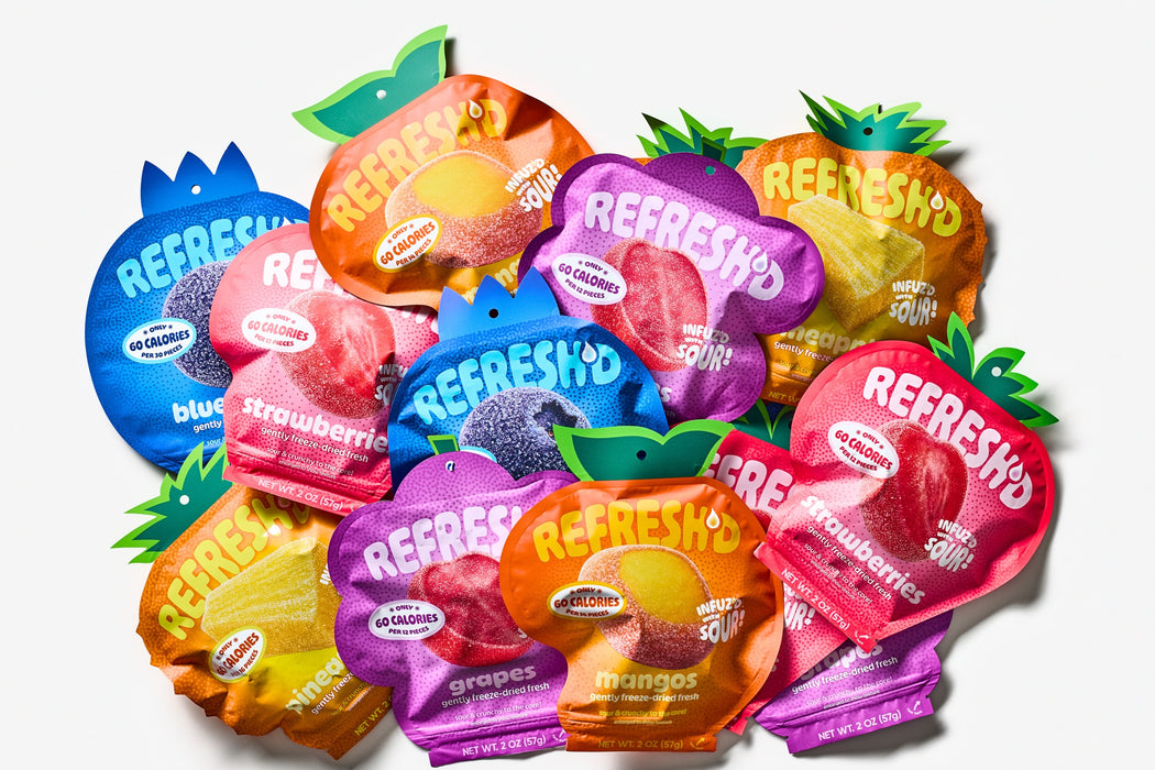 A pile of REFRESH'D pouches in all five flavors: strawberries, blueberries, grapes, mangos and pineapples