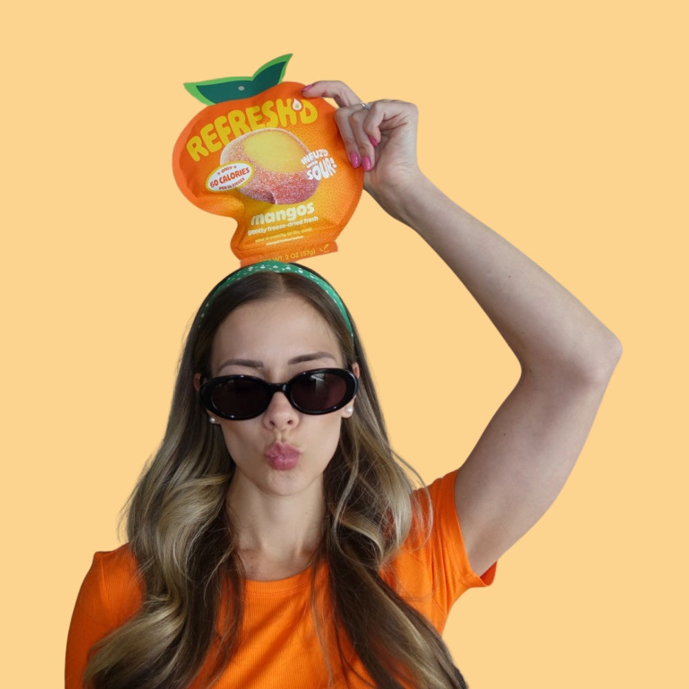 Pouch held overhead, sour freeze-dried mangos