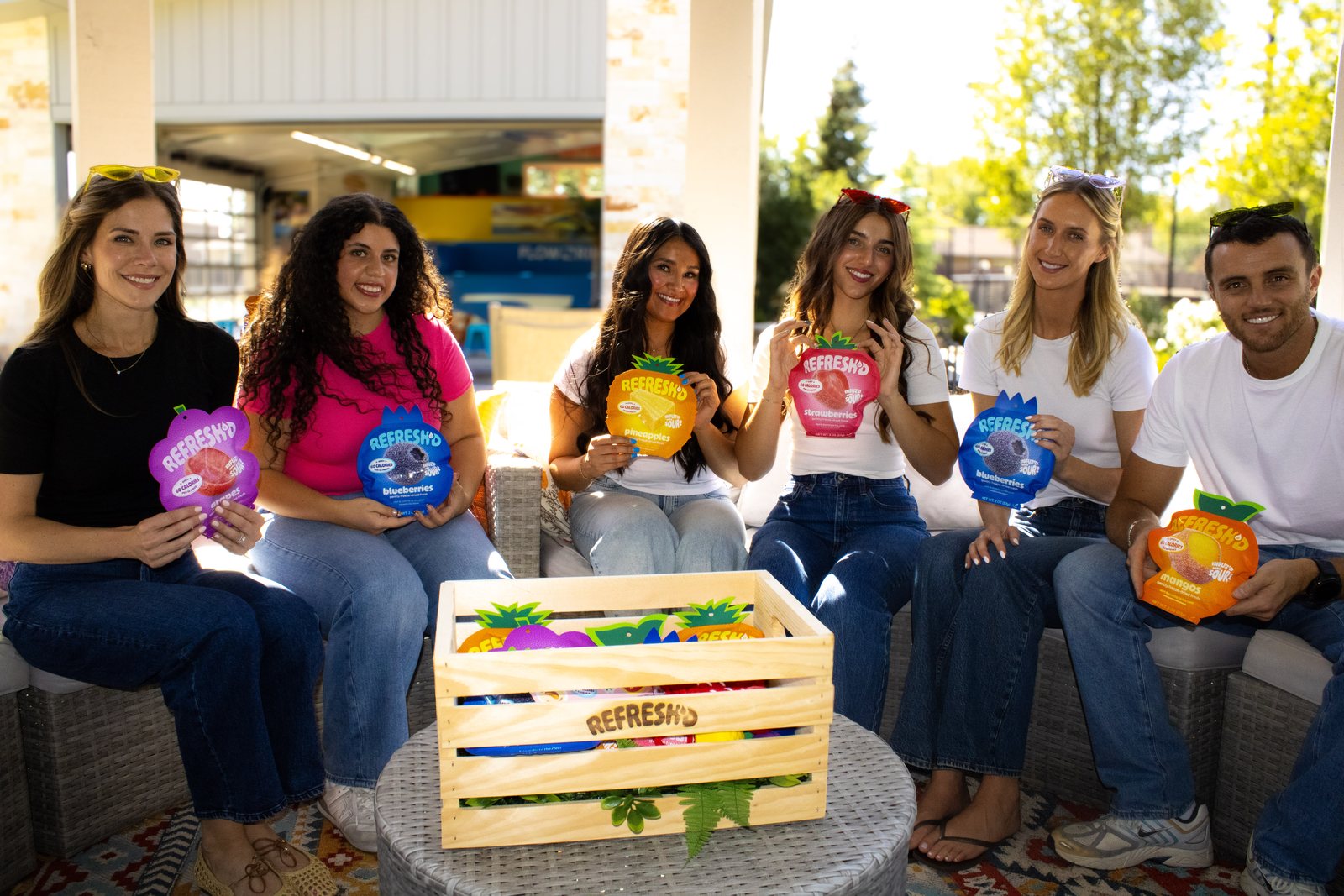 Six people sitting together, each holding a pouch.