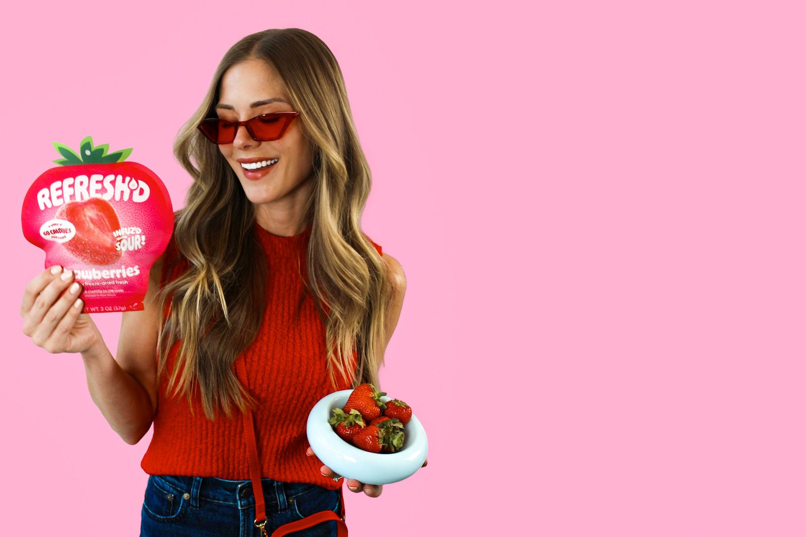Someone holding a pouch of REFRESH'D sour freeze-dried strawberries.
